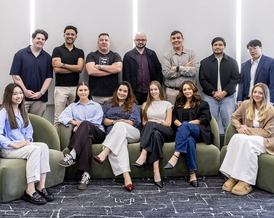 The whole team together on and around a green sofa